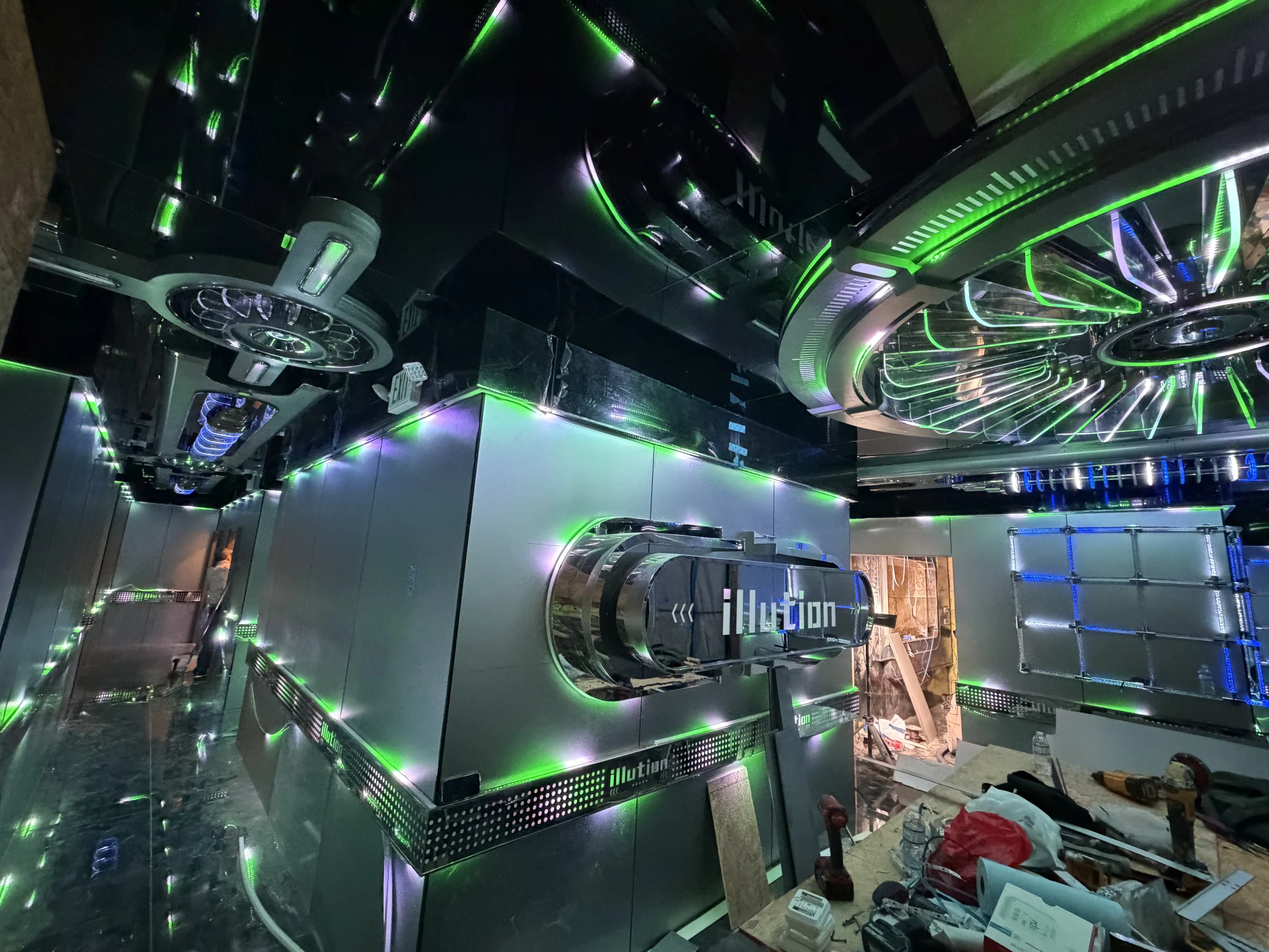 Completed Illution entertainment venue interior with green architectural lighting and mirrored ceiling features